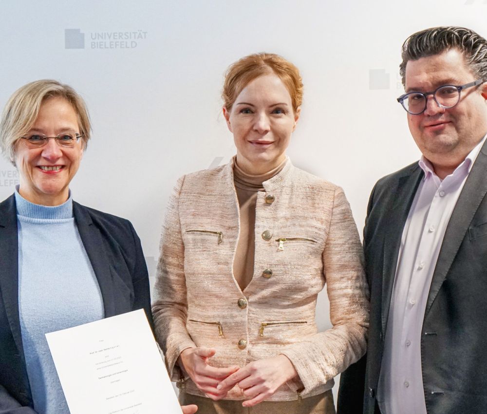 Die Rektorin der Universität Bielefeld Prof. Dr. Angelika Epple (l.) übergibt Univ.-Prof. Dr. Selma Ugurel (Mitte) ihre Ernennungsurkunde im Beisein von Bernd Henkemeier, Kaufmännischer Direktor des Klinikum Bielefeld (r.).