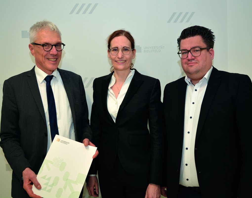 Der Kanzler der Universität Bielefeld Dr. Stephan Becker (l.) übergibt Univ.-Prof. Dr. Claudia Scherl (Mitte) ihre Ernennungsurkunde im Beisein von Bernd Henkemeier, kaufmännischer Direktor des Klinikum Bielefeld (r.).