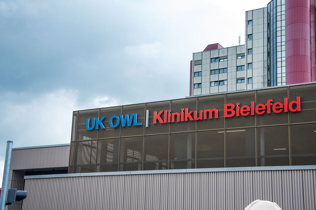 Bild NIZ Eröffnung UK OWL Klinikum Bielefeld Schriftzug auf der Wagenhalle